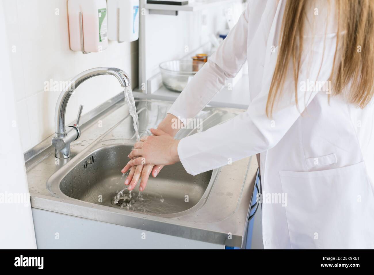 Crop view of female scientist washing hands at laboratory Stock Photo