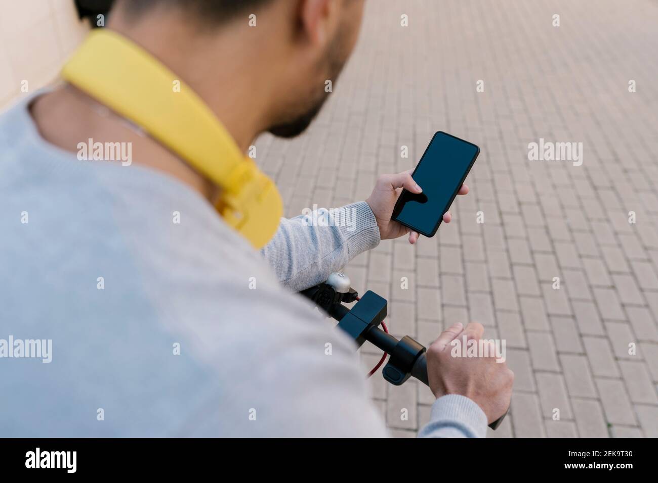 Young man with electric push scooter using smart phone Stock Photo