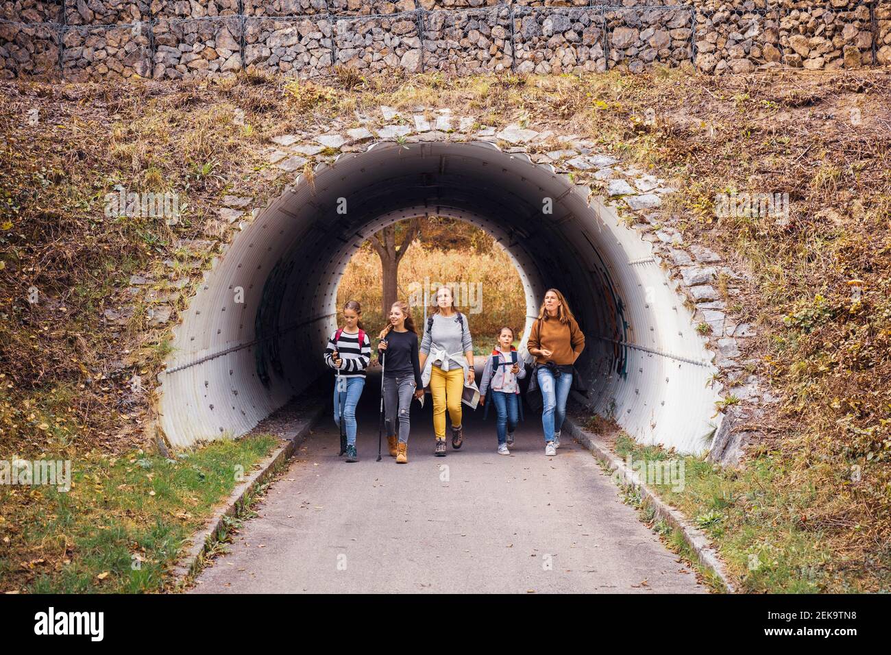 Explorers walking through underpass at countryside Stock Photo