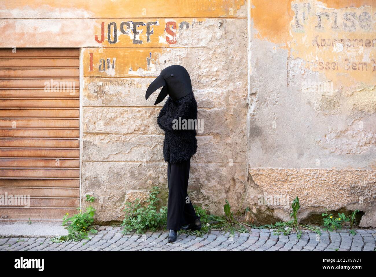 Woman with crow costume standing against old wall Stock Photo