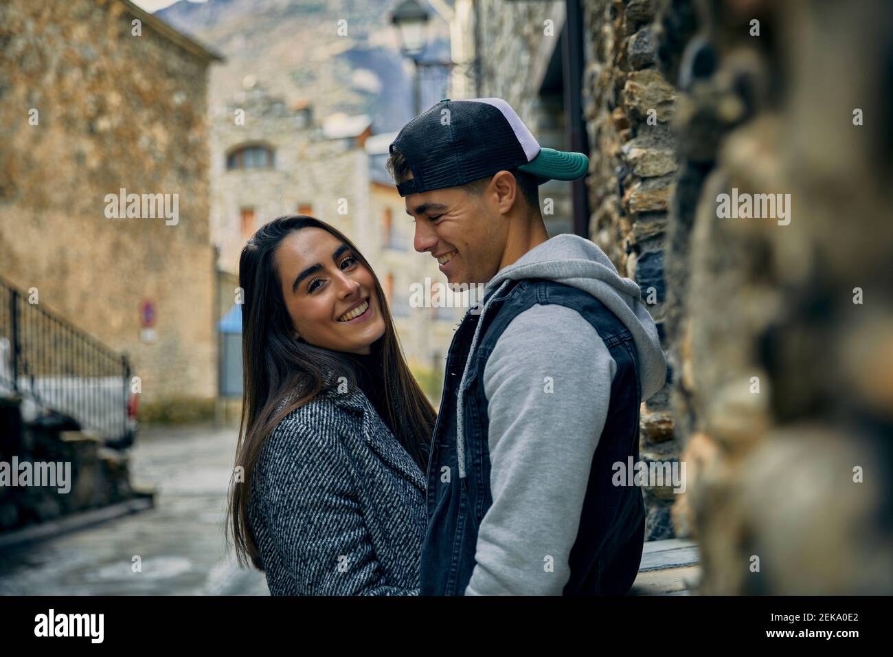 Smiling young man looking at girlfriend while standing in town Stock Photo