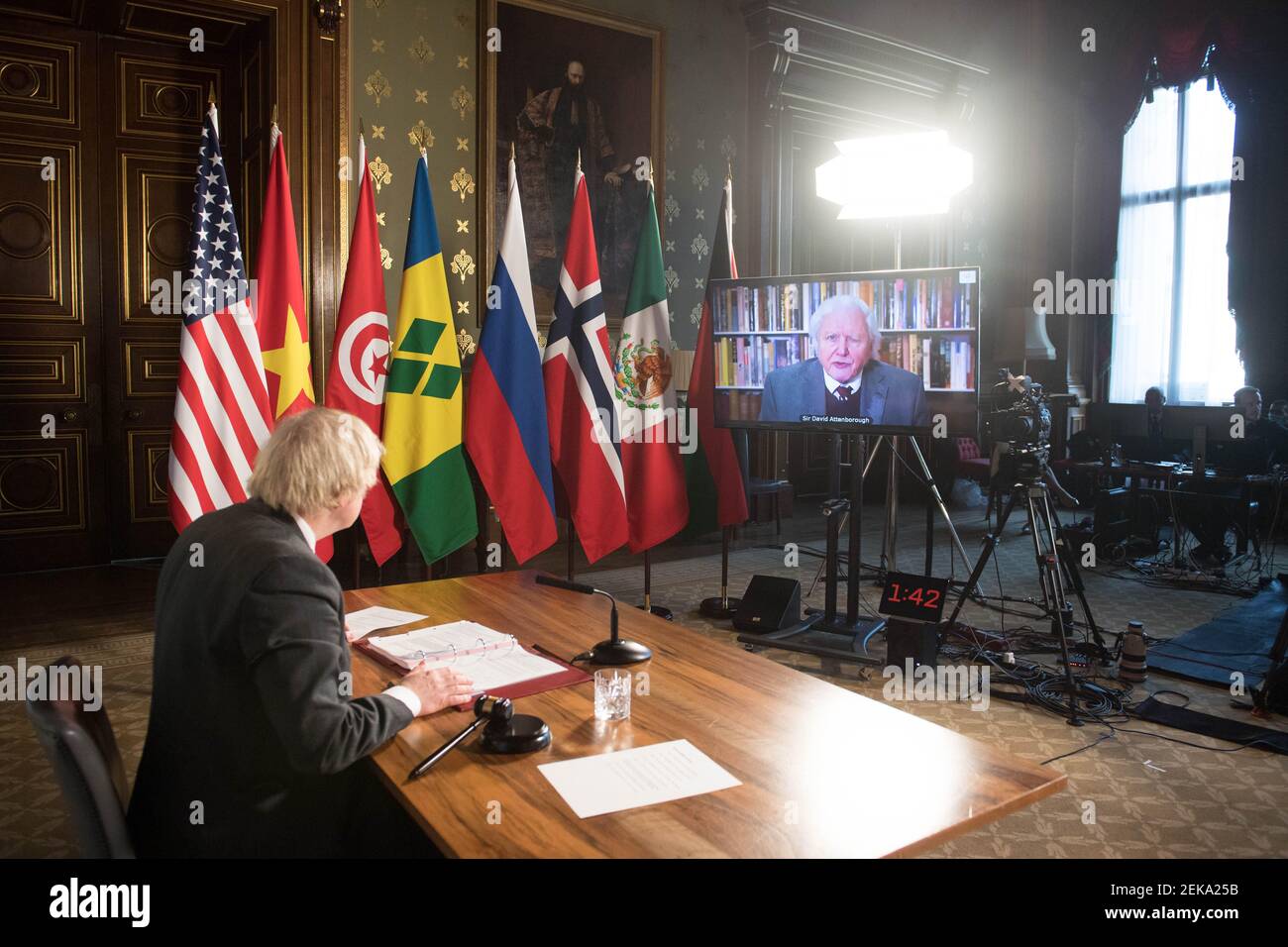 Prime Minister Boris Johnson watches a video address by Sir David Attenborough at a session of the UN Security Council on climate and security at the Foreign, Commonwealth and Development Office in London. Picture date: Tuesday February 23, 2021. Stock Photo