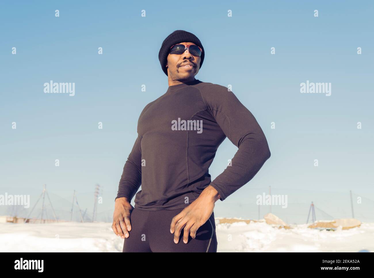 Confident sportsman wearing knit hat looking away while standing against sky Stock Photo