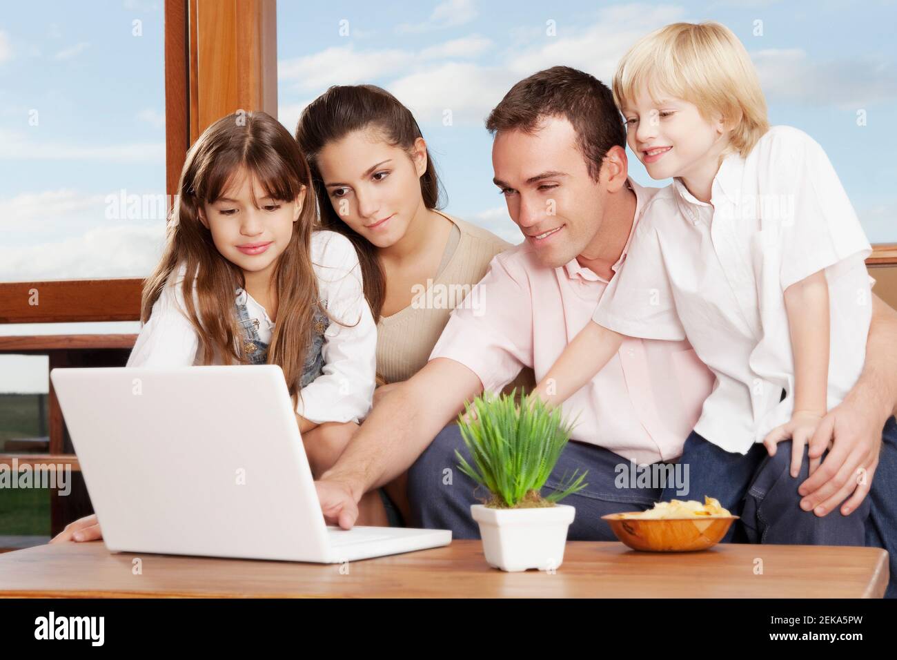 Family using a laptop at home Stock Photo - Alamy