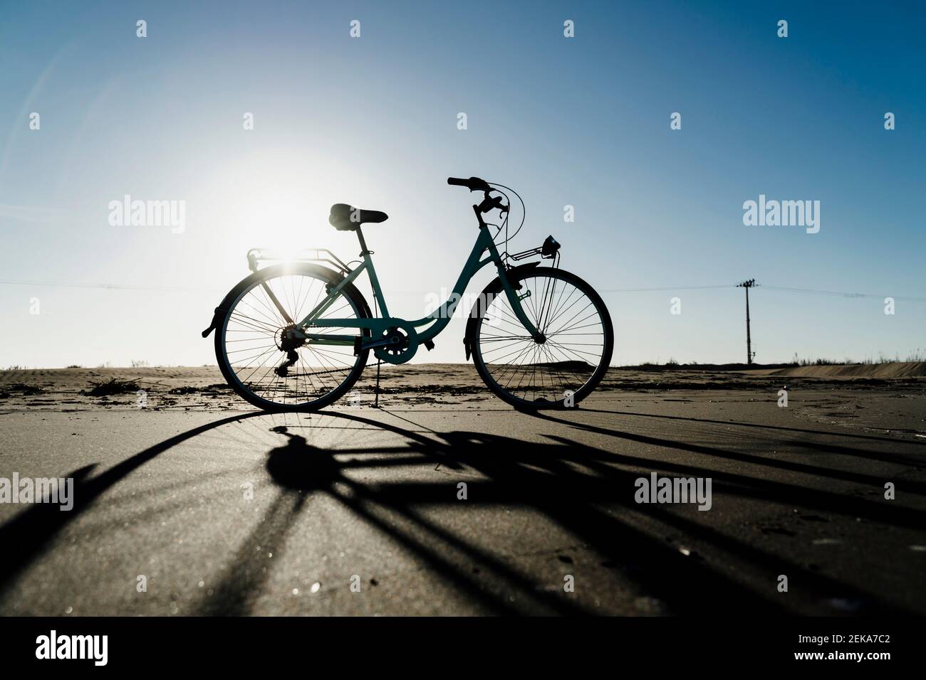 Silhouette bicycle parked at Fangar Beach against clear sky in sunlight, Ebro delta. Spain Stock Photo