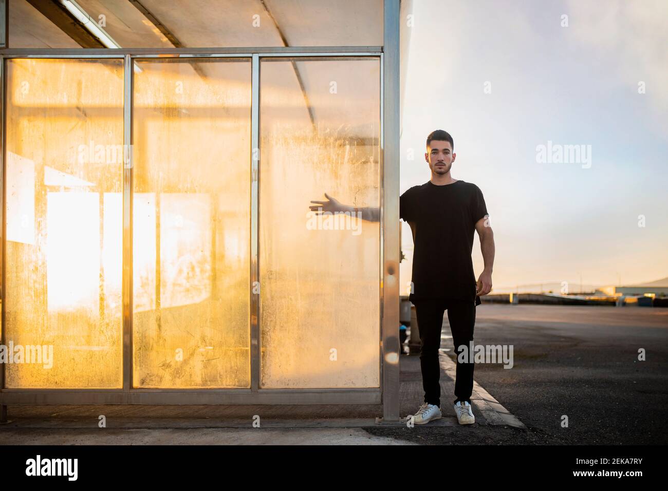 Man with hand on glass standing by car wash station Stock Photo