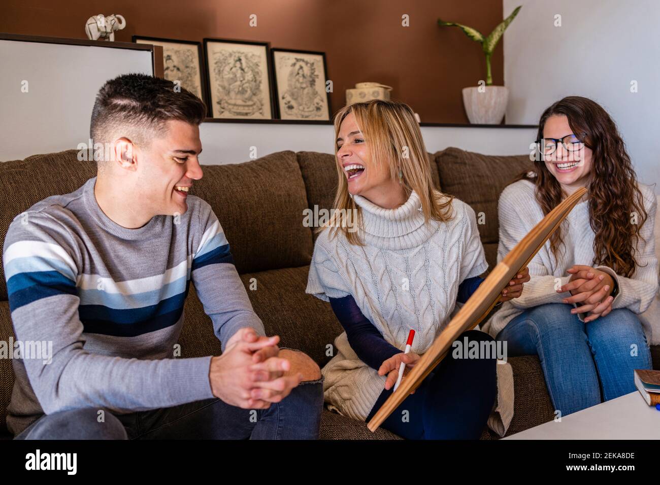 Female counselor with young patients laughing during session at work place Stock Photo