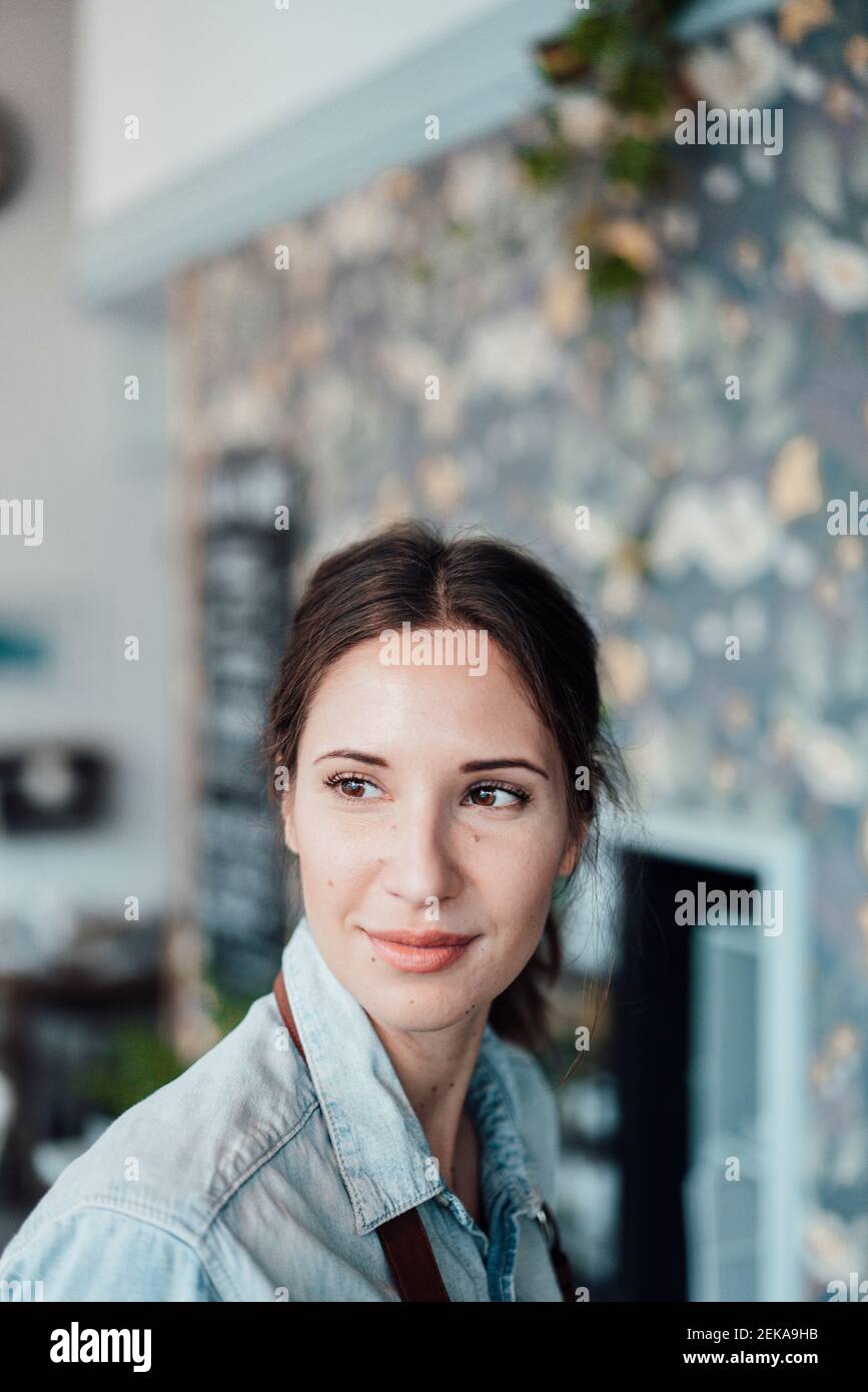 Thoughtful female owner looking away in coffee shop Stock Photo