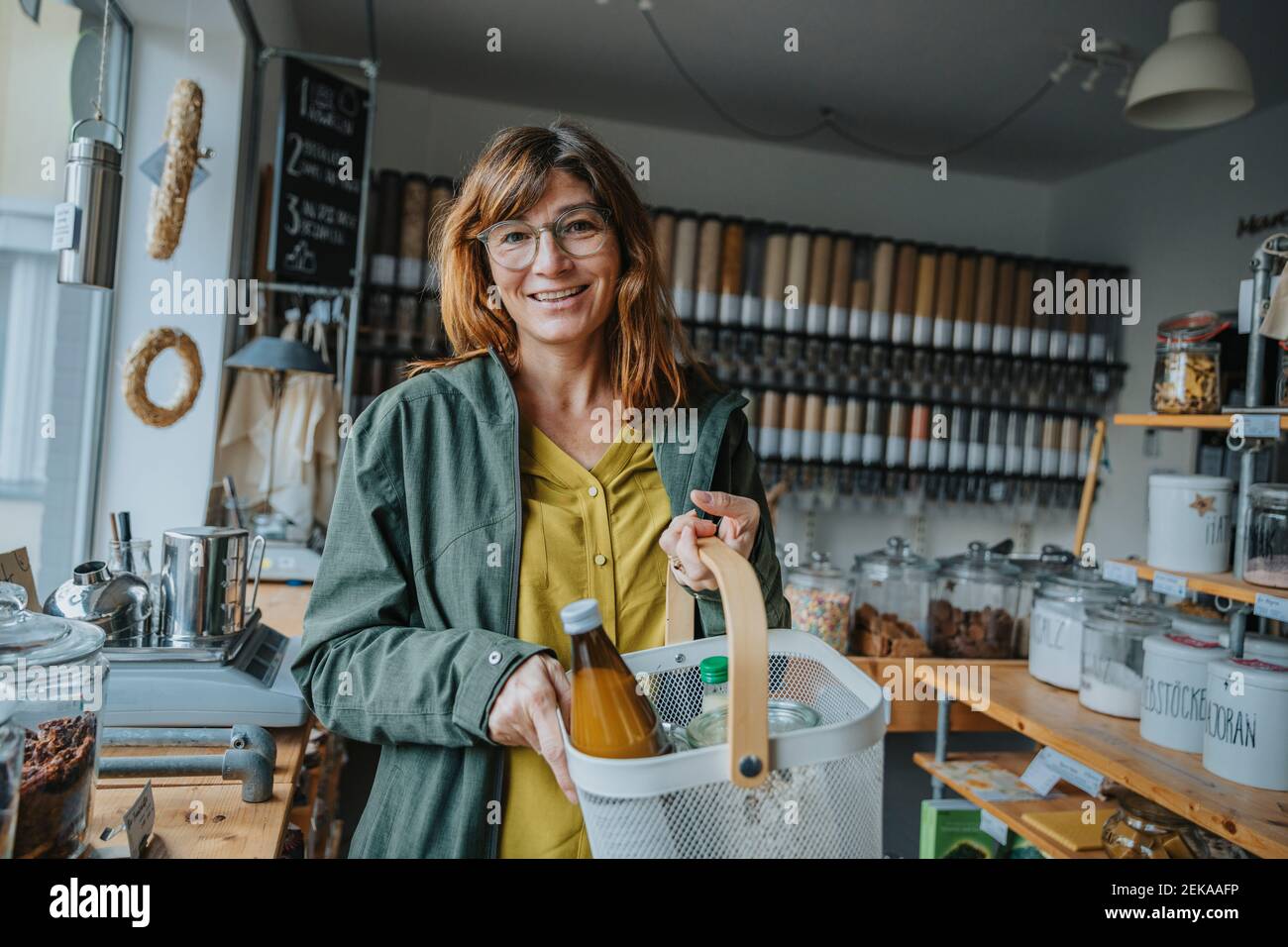 Happy mature female customer wearing eyeglasses shopping groceries in retail store Stock Photo