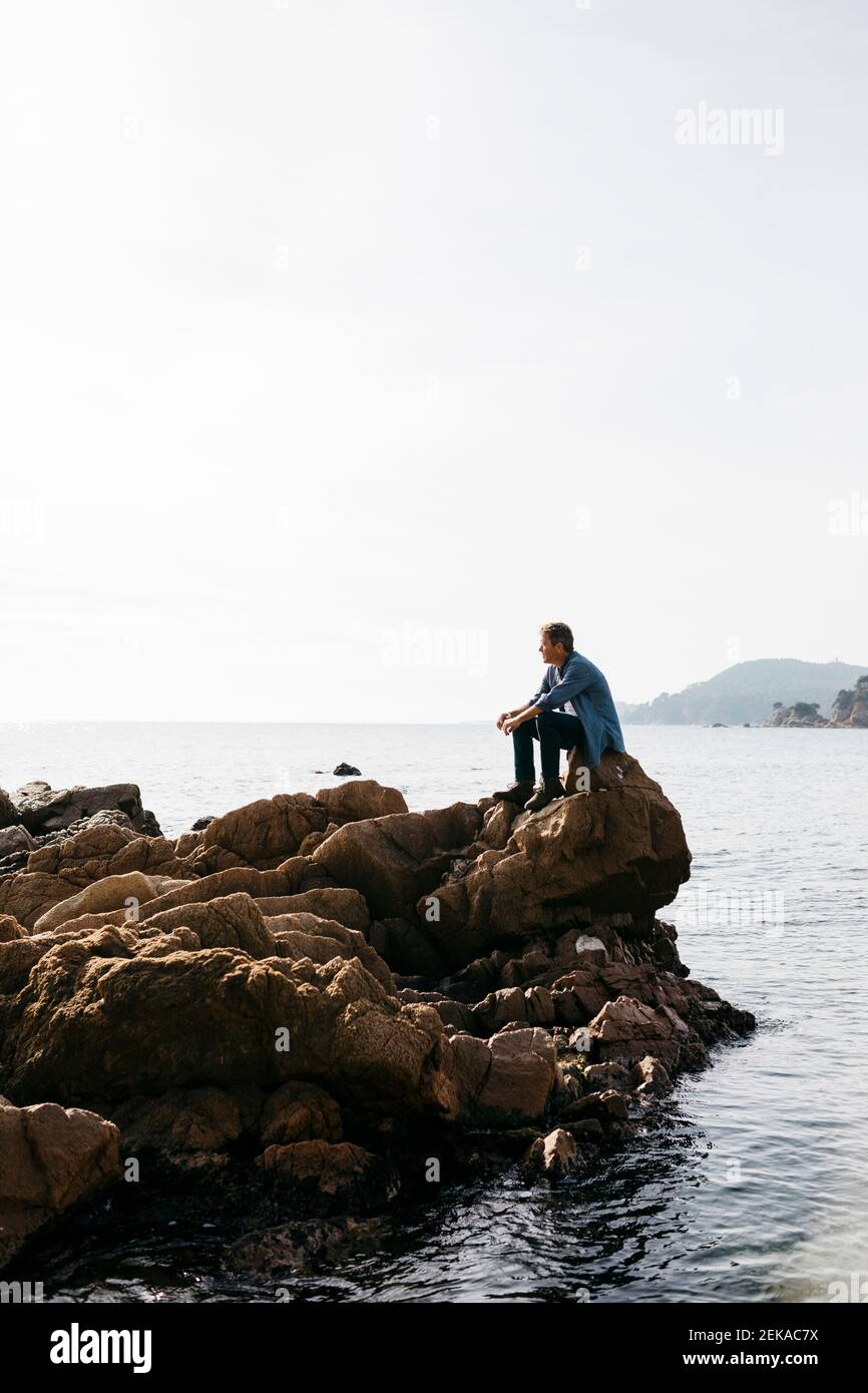 Man sitting on rock looking hi-res stock photography and images - Alamy