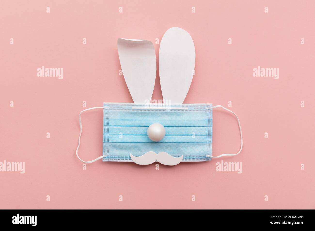 Coronavirus Easter bunny face made from rabbit ears and a protective face mask Stock Photo