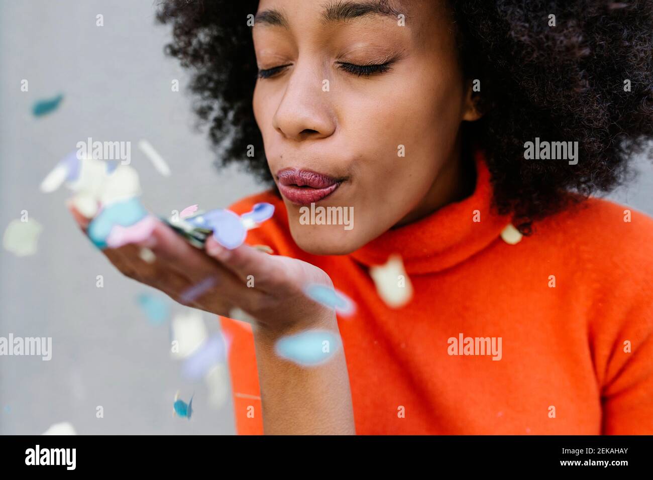 Young woman blowing confetti Stock Photo