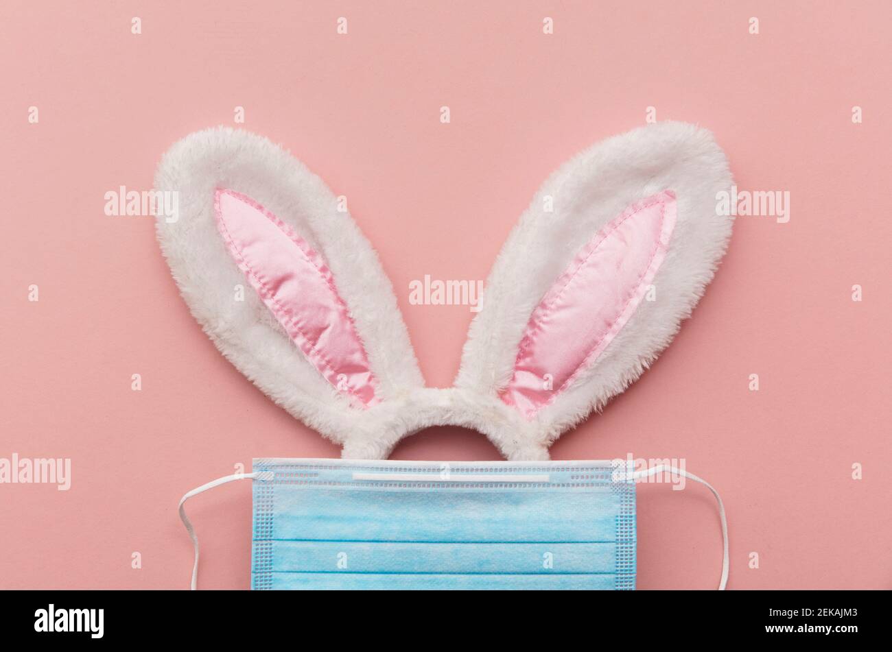 Coronavirus Easter bunny face made from rabbit ears and a protective face mask Stock Photo