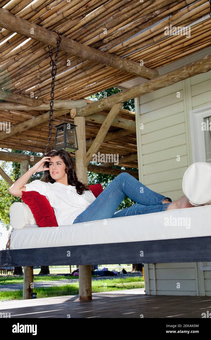 Woman resting on a porch swing Stock Photo - Alamy
