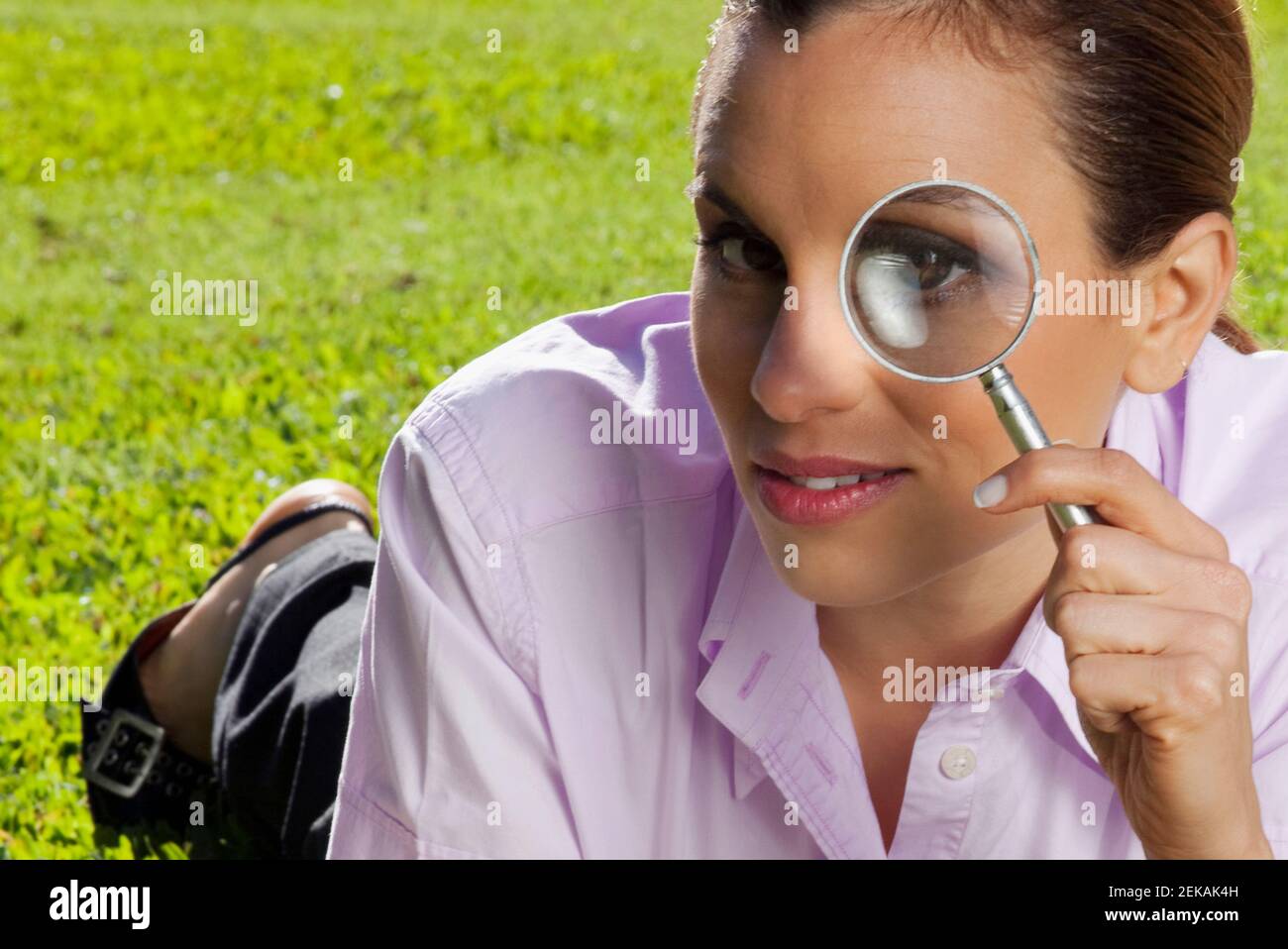 Businesswoman looking through a magnifying glass in a park Stock Photo ...