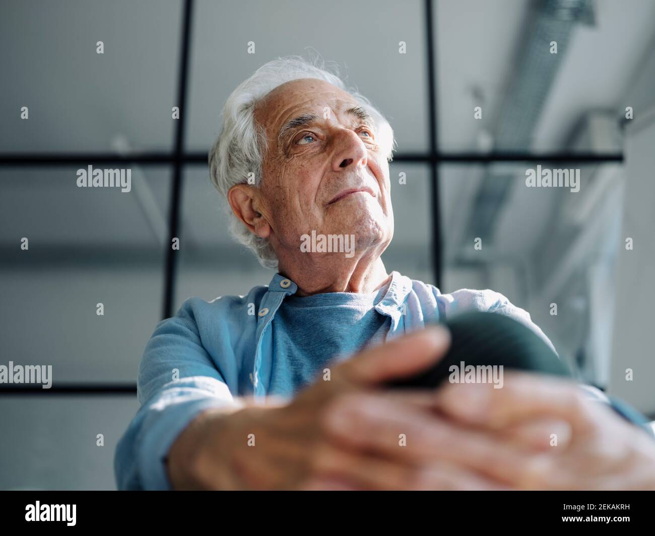 Thoughtful businessman looking away while sitting at office Stock Photo
