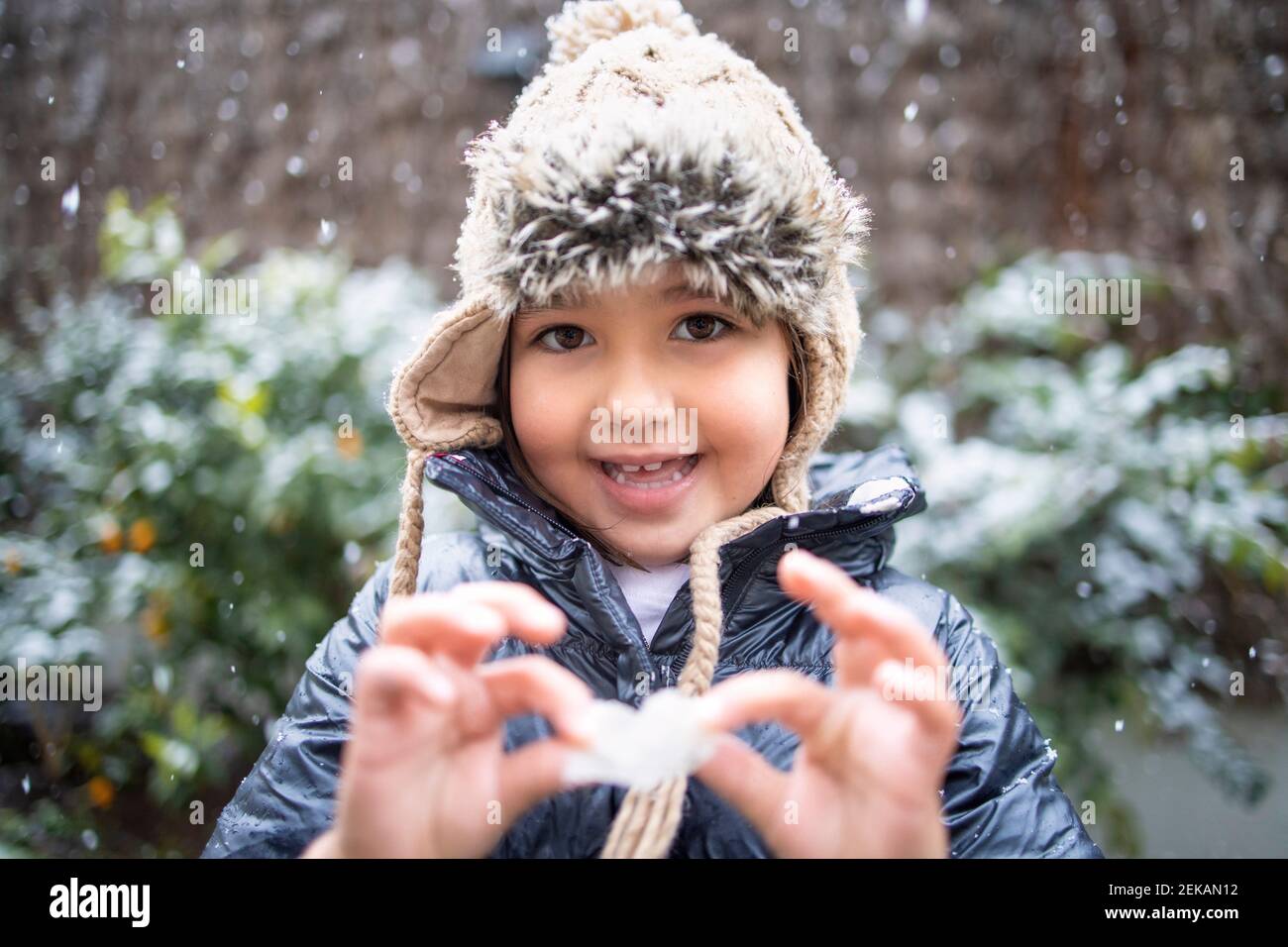 Cute girl in knit hat during snow Stock Photo