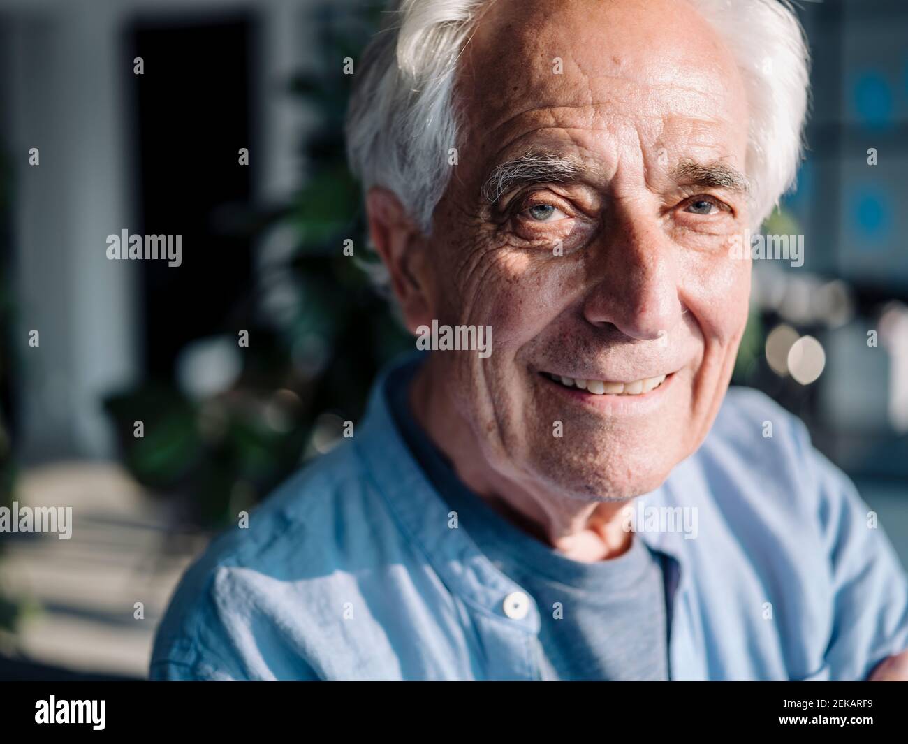 Smiling businessman staring while standing at office Stock Photo
