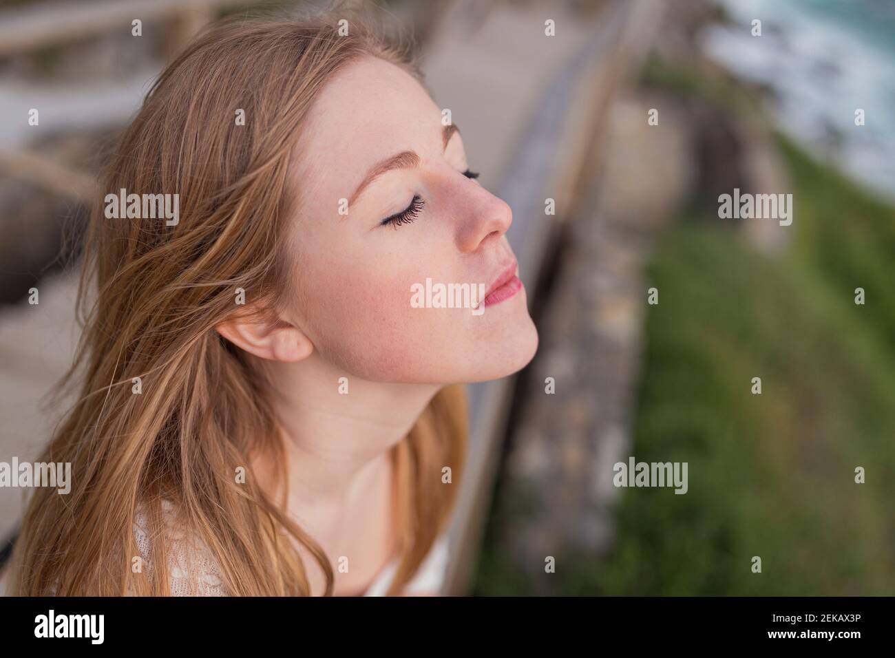 Blond woman with eyes closed at observation point Stock Photo - Alamy
