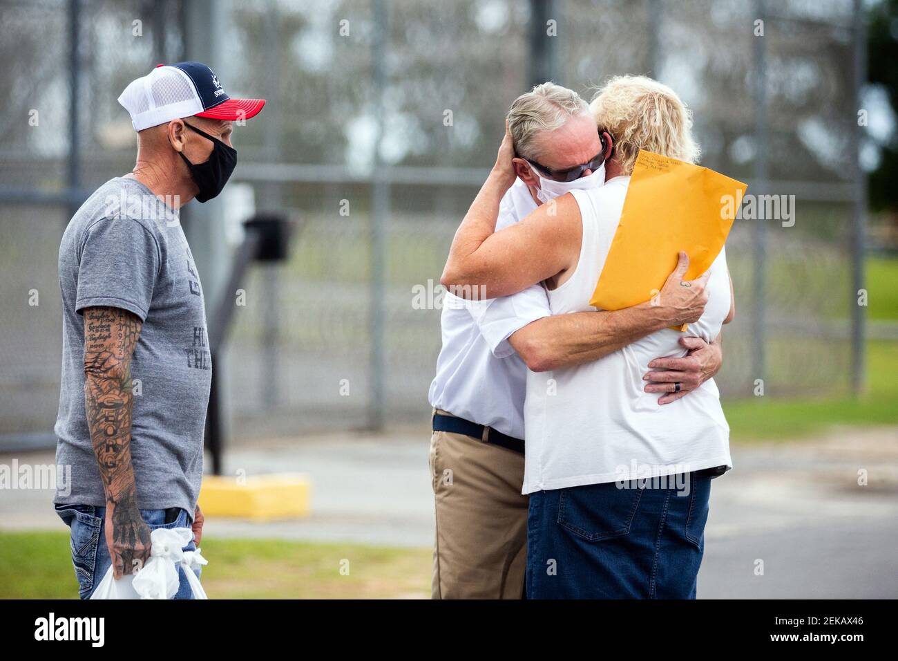 Dennis Perry, middle, is greeted by his wife Brenda Perry, right, and