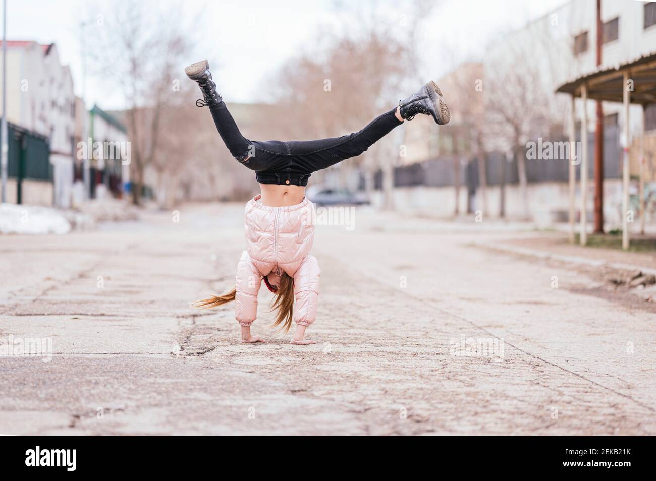 Girl doing handstand on road against sky Stock Photo - Alamy