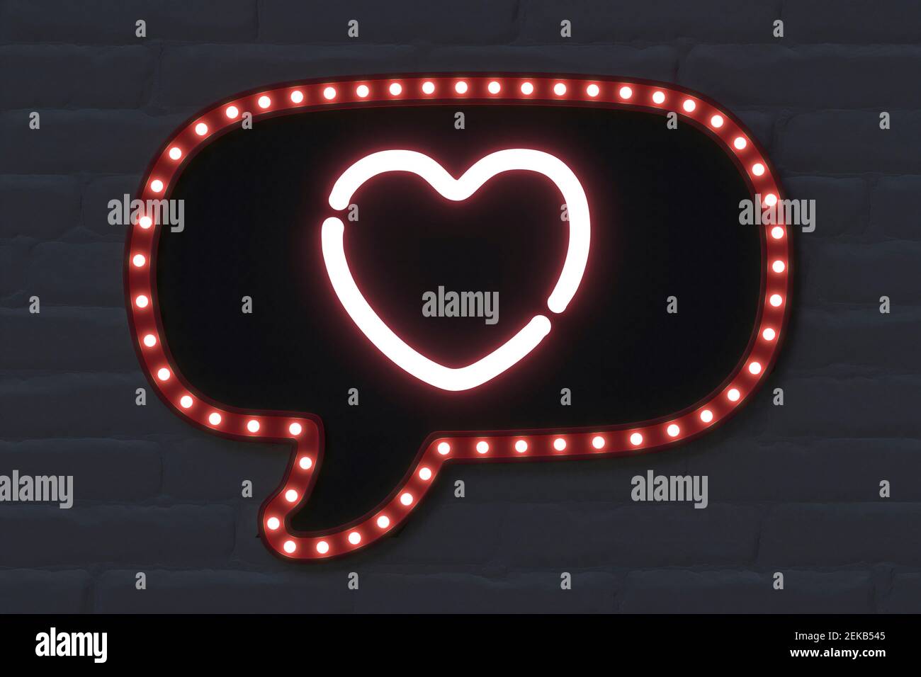 Illuminated speech bubble with heart shape on black brick wall Stock Photo