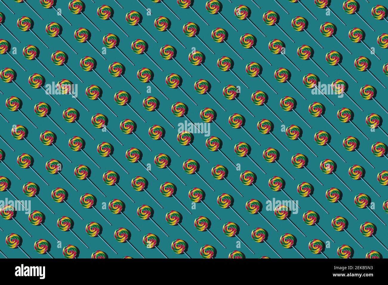 Pattern of multi colored lollipops against green background Stock Photo