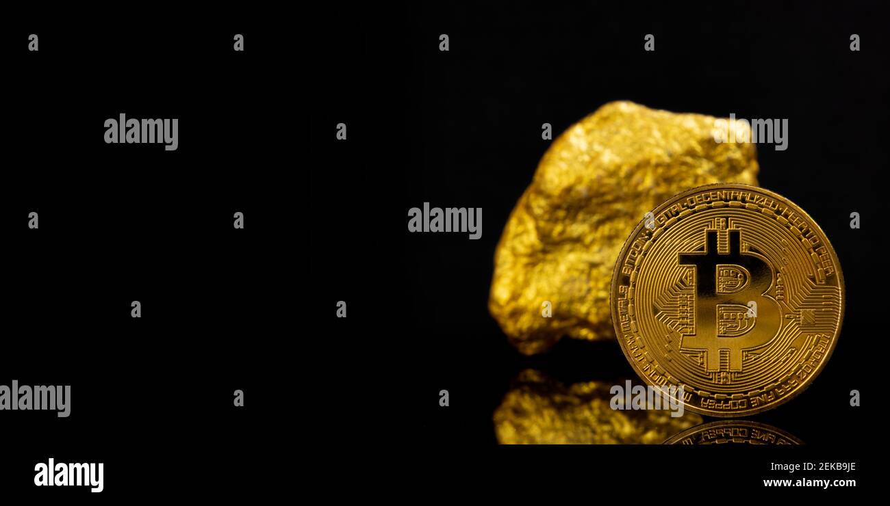 Investment sources on stock markets and financial concept: Close up on a golden bitcoin with a real raw gold piece behind. Reflection Stock Photo