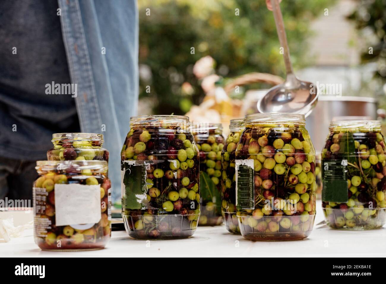 Man preparing olives in jars Stock Photo
