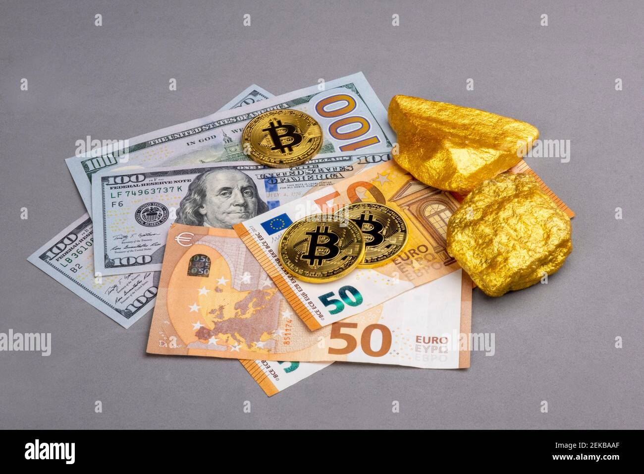Economic concept: Crypto currency, money and gold on global stock markets.  Three shiny bitcoin, two gold pieces on some EURO and US dollar banknotes  Stock Photo - Alamy