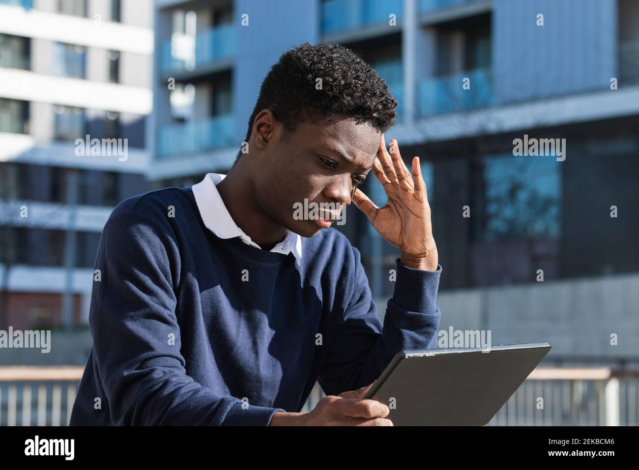 Serious young man with digital tablet against building Stock Photo