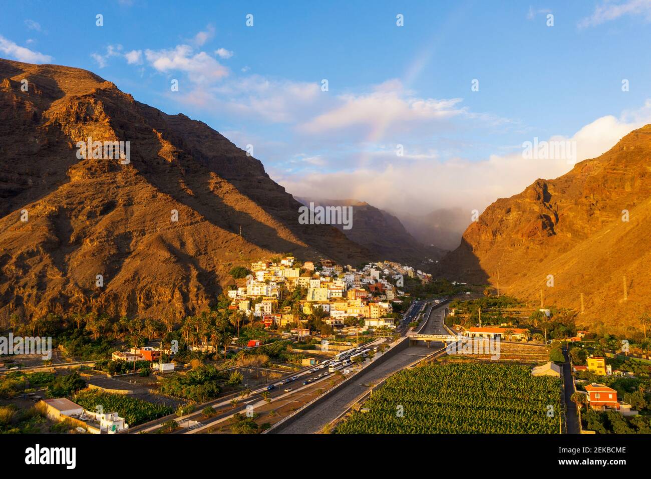 Rainbow over town in valley Stock Photo