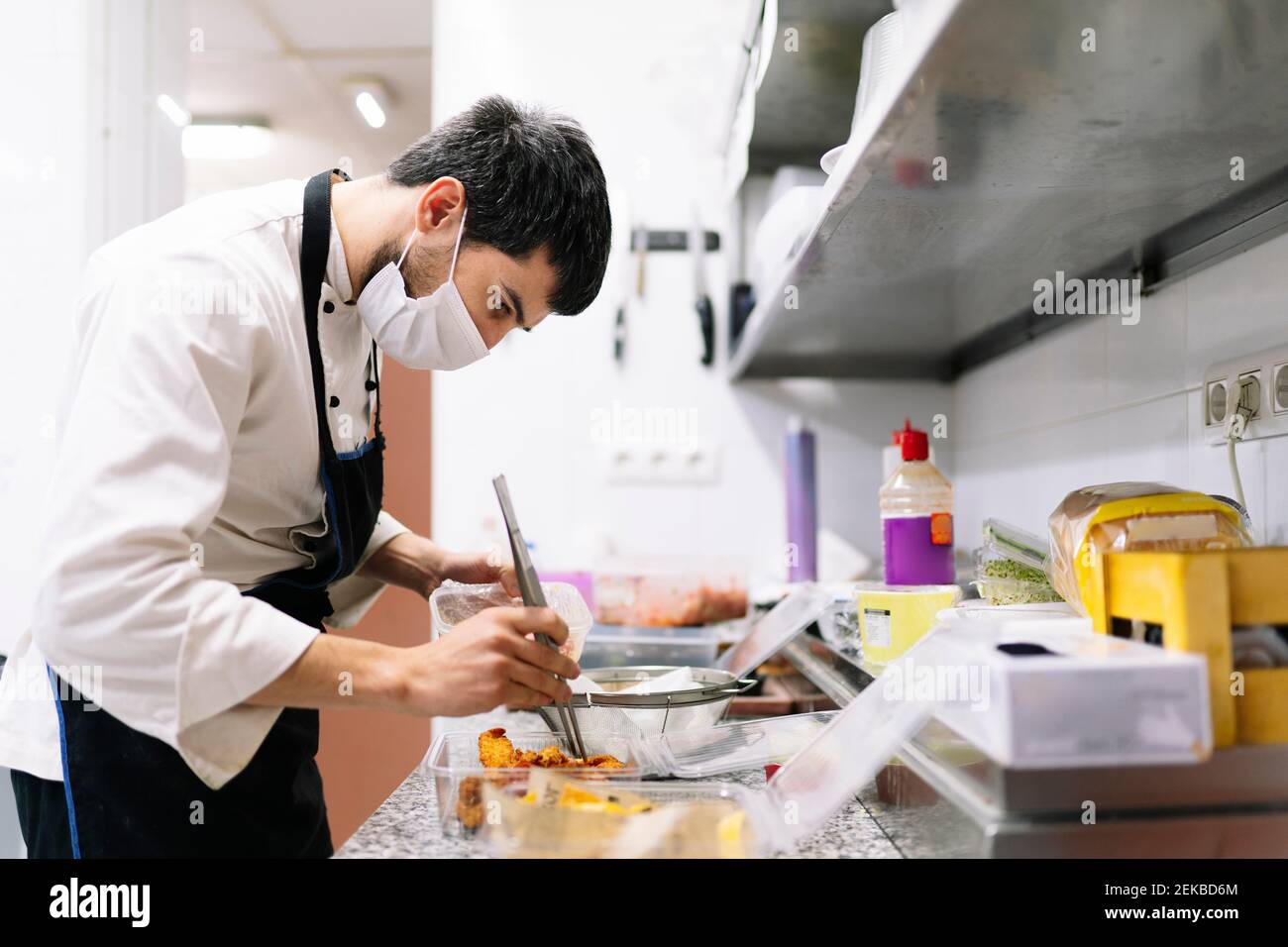 Male chef preparing food in plastic containers in kitchen at restaurant  during COVID-19 Stock Photo - Alamy