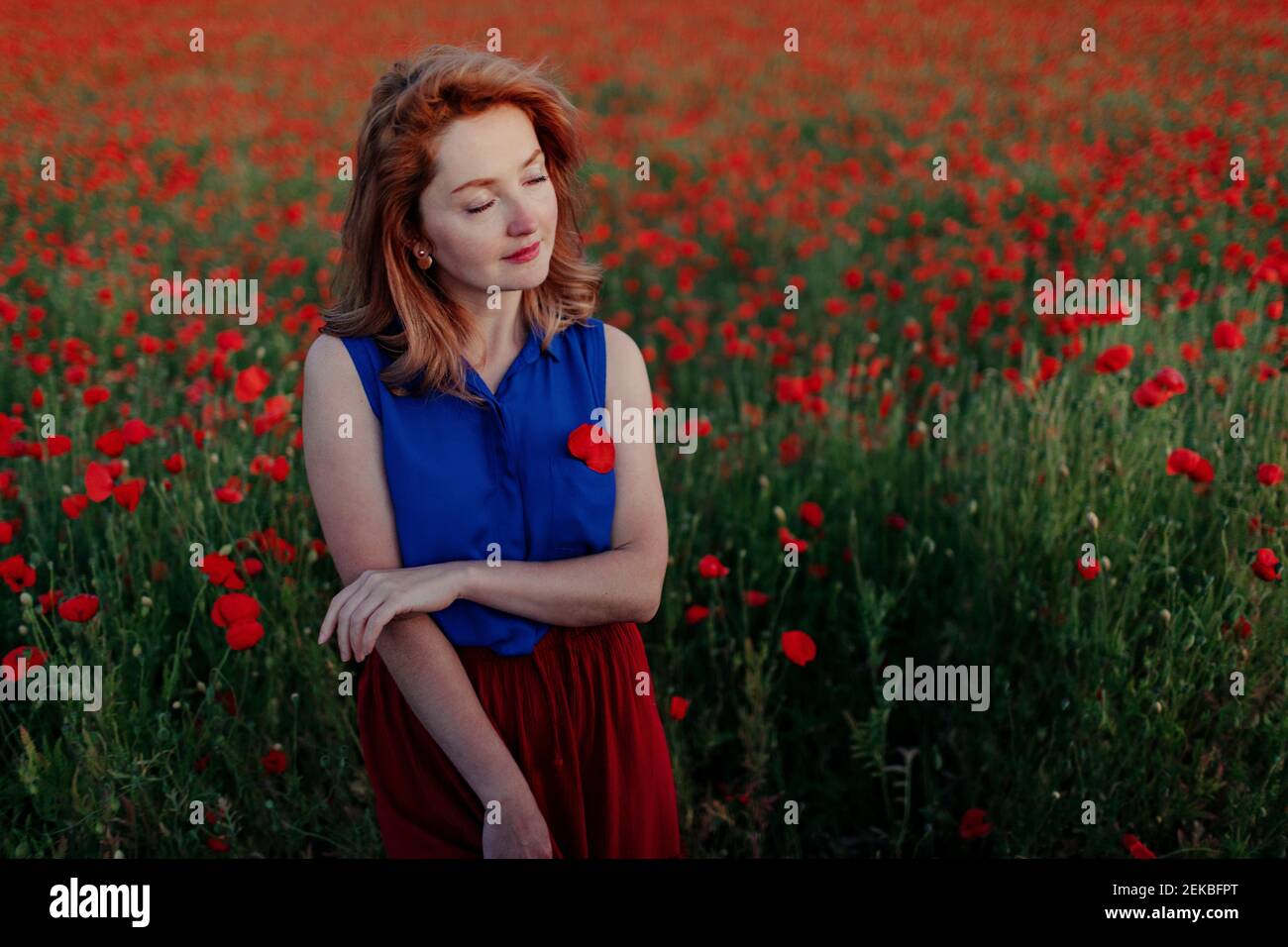 Beautiful woman with eyes closed in poppy field Stock Photo