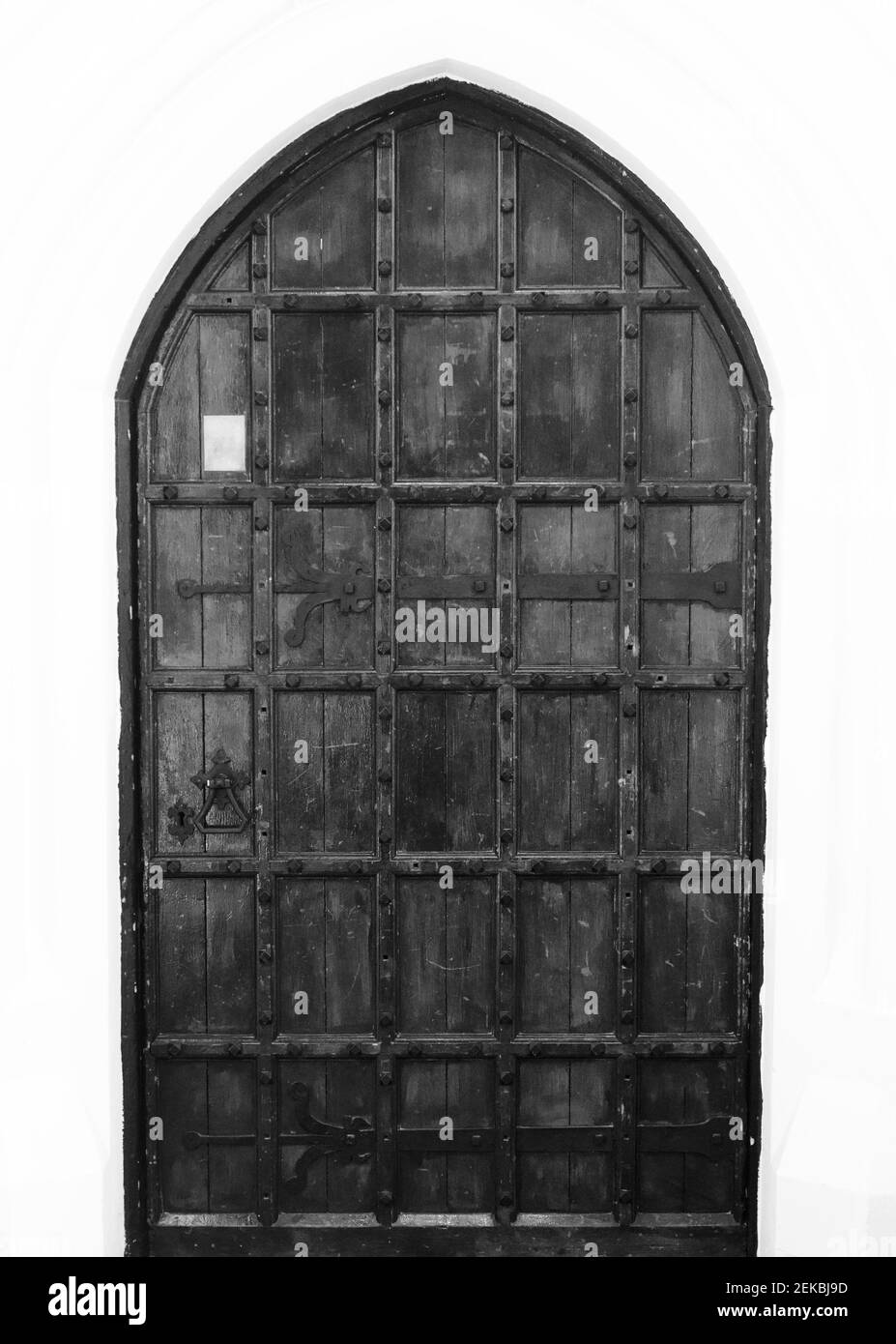 Black and white image of old elizabethan door with metal furniture Stock Photo