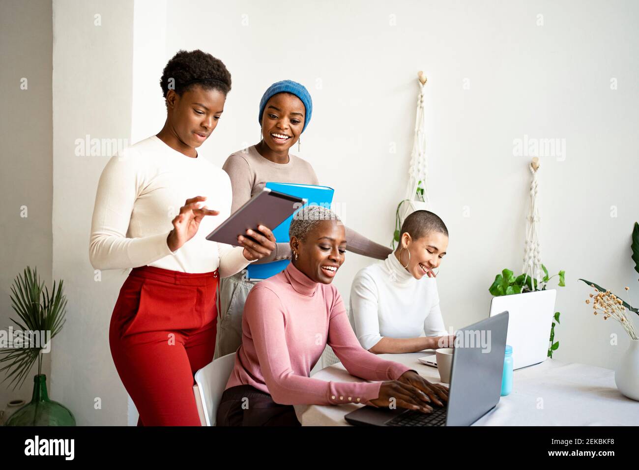 Smiling multi-ethnic female colleagues working at home Stock Photo