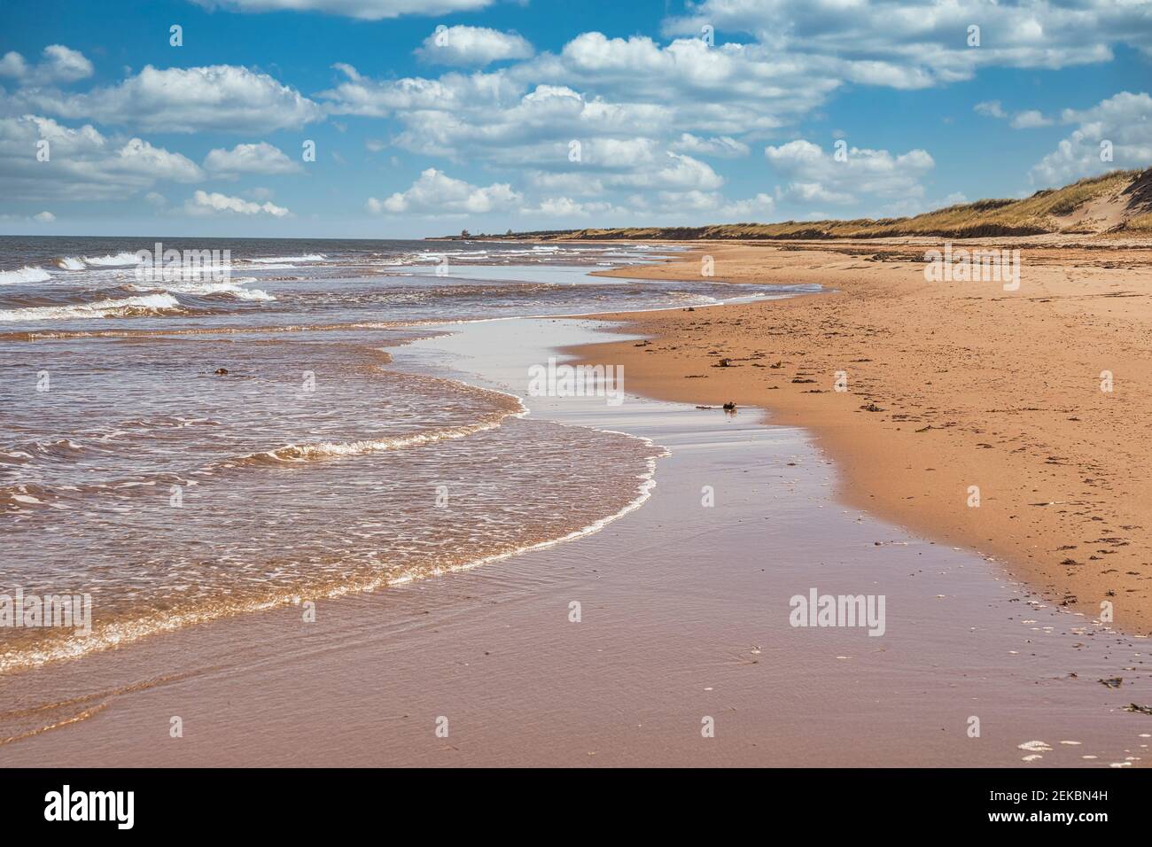 Waves lap up on a sandy beach on the north shore of Prince Edward Island, Canada. Stock Photo