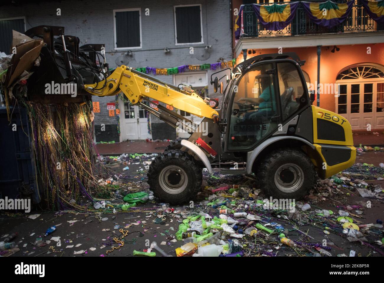 Bulldozer cleaning Trash-filled streets late night morning after Mardi Gras, New Orleans, Louisiana, USA. Bourbon Street. Stock Photo