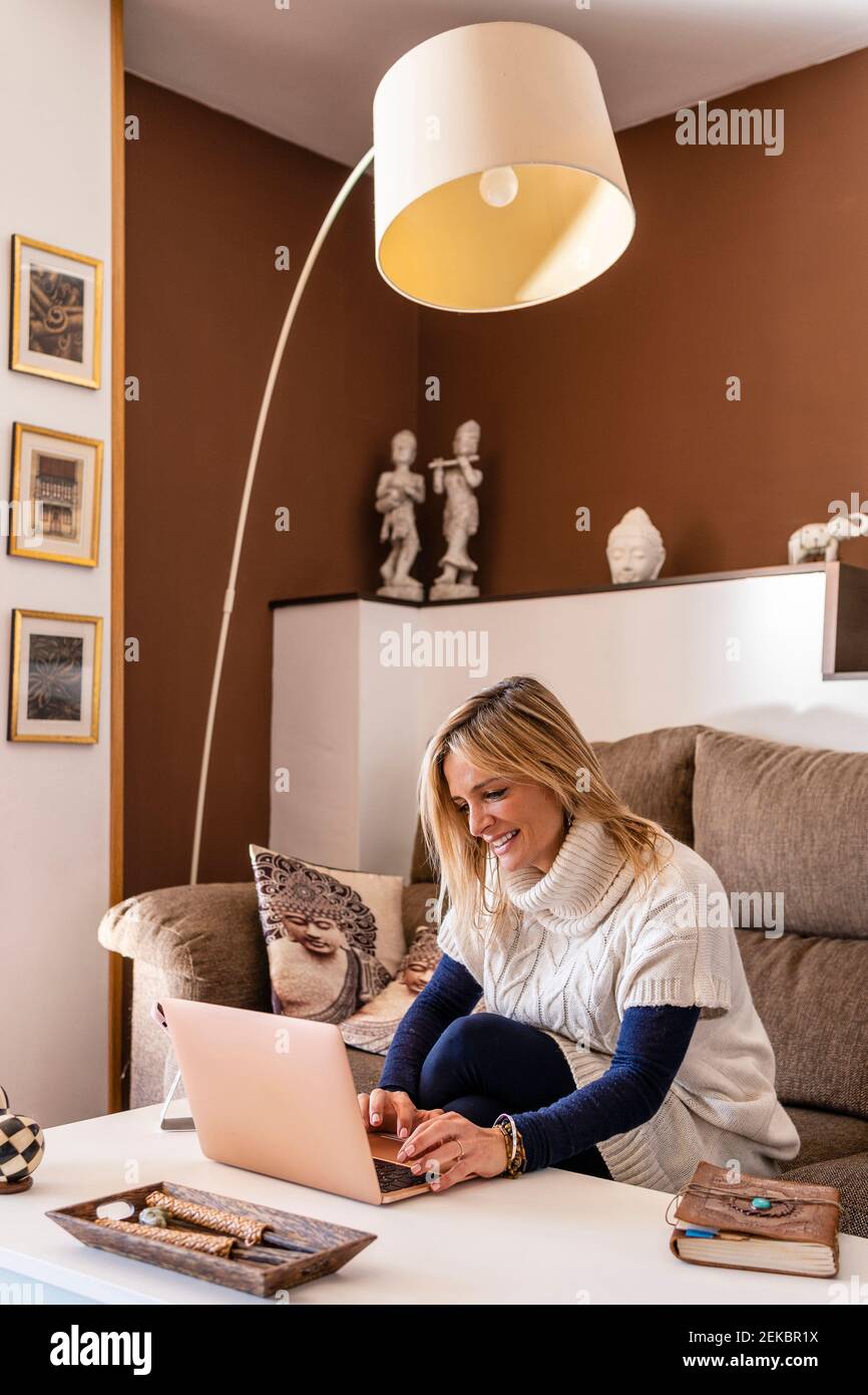 Smiling female psychologist working on laptop at table in work place Stock Photo