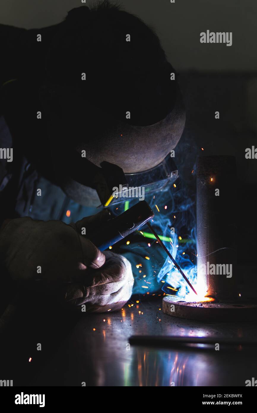 Male welder in protective work wear working at workshop Stock Photo