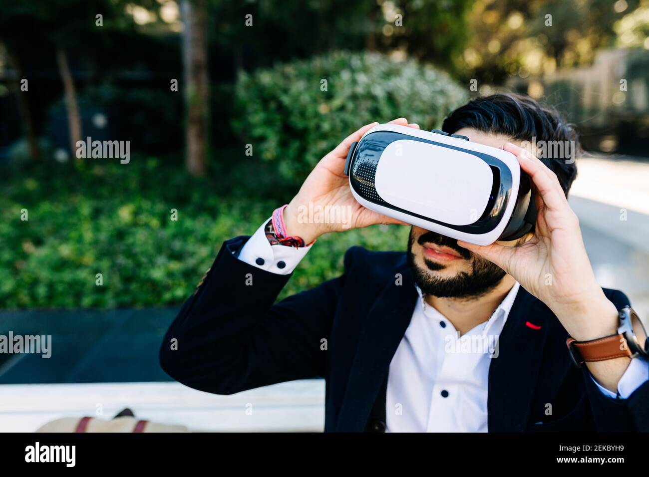 Businessman using virtual reality simulator while sitting outdoors Stock Photo