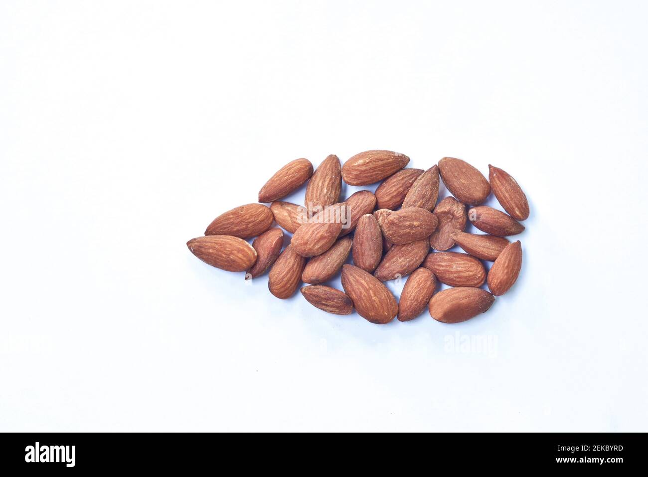 salty baked almond seed batch on white background Stock Photo