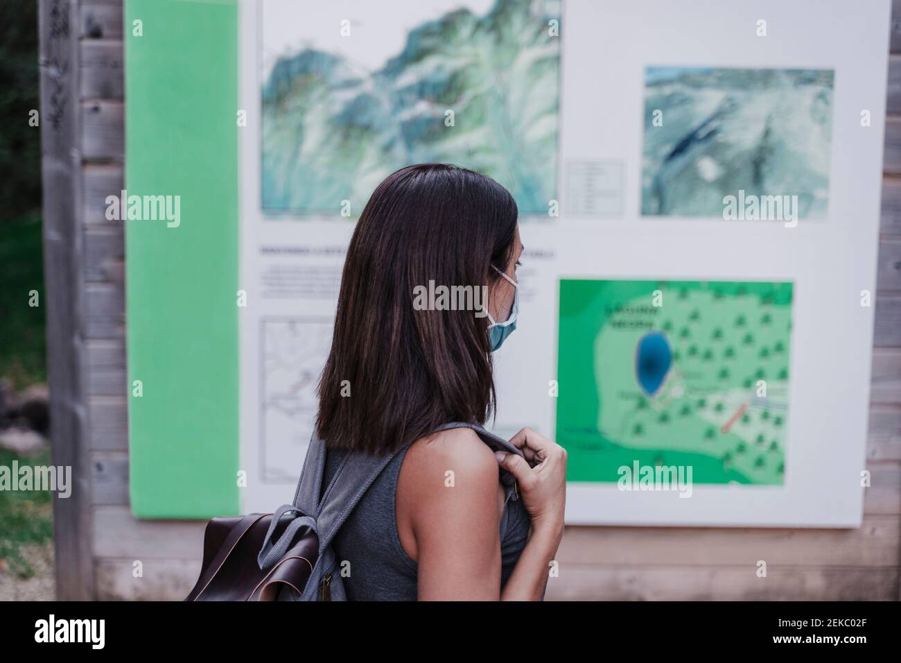 Female hiker wearing face mask looking at map Stock Photo