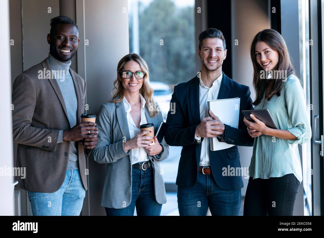 Confident business team smiling while standing together at office Stock ...