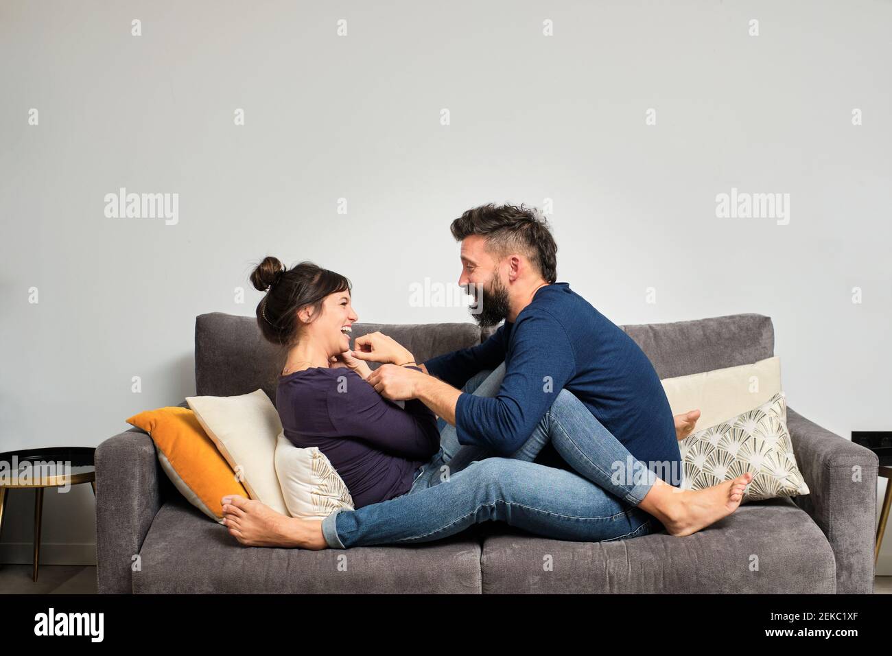 Adult couple sitting together on sofa Stock Photo Alamy