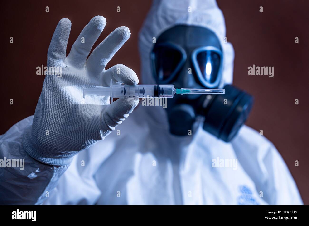 Mature man in tear gas mask holding syringe Stock Photo