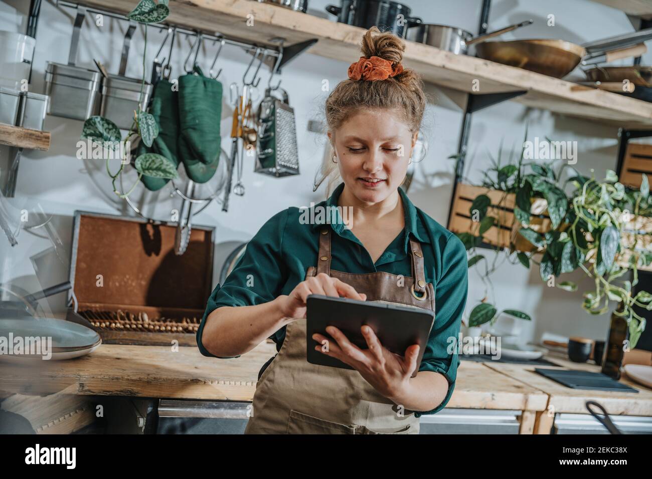 Young chef using digital tablet while standing in kitchen Stock Photo