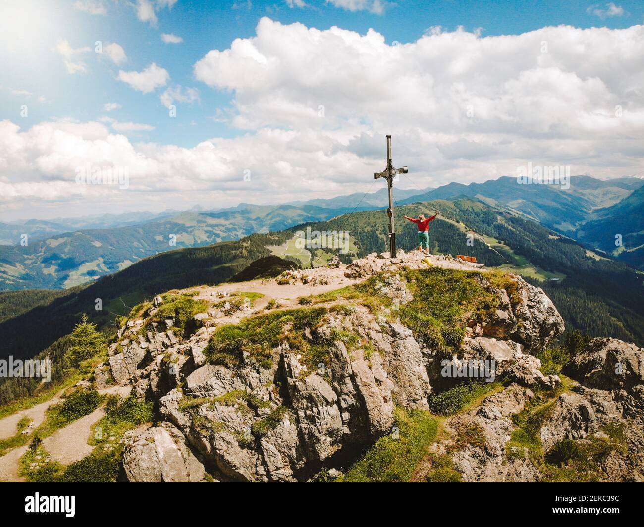 Drone shot of woman standing on mountain peak against cloudy sky Stock  Photo - Alamy