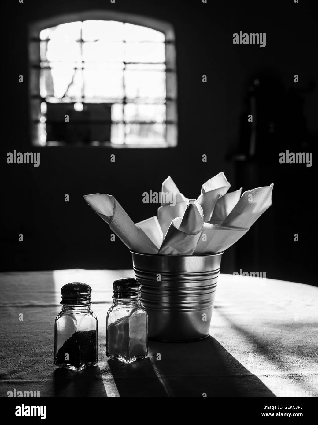 A pair of salt and pepper and shakers, napkins on table Stock Photo