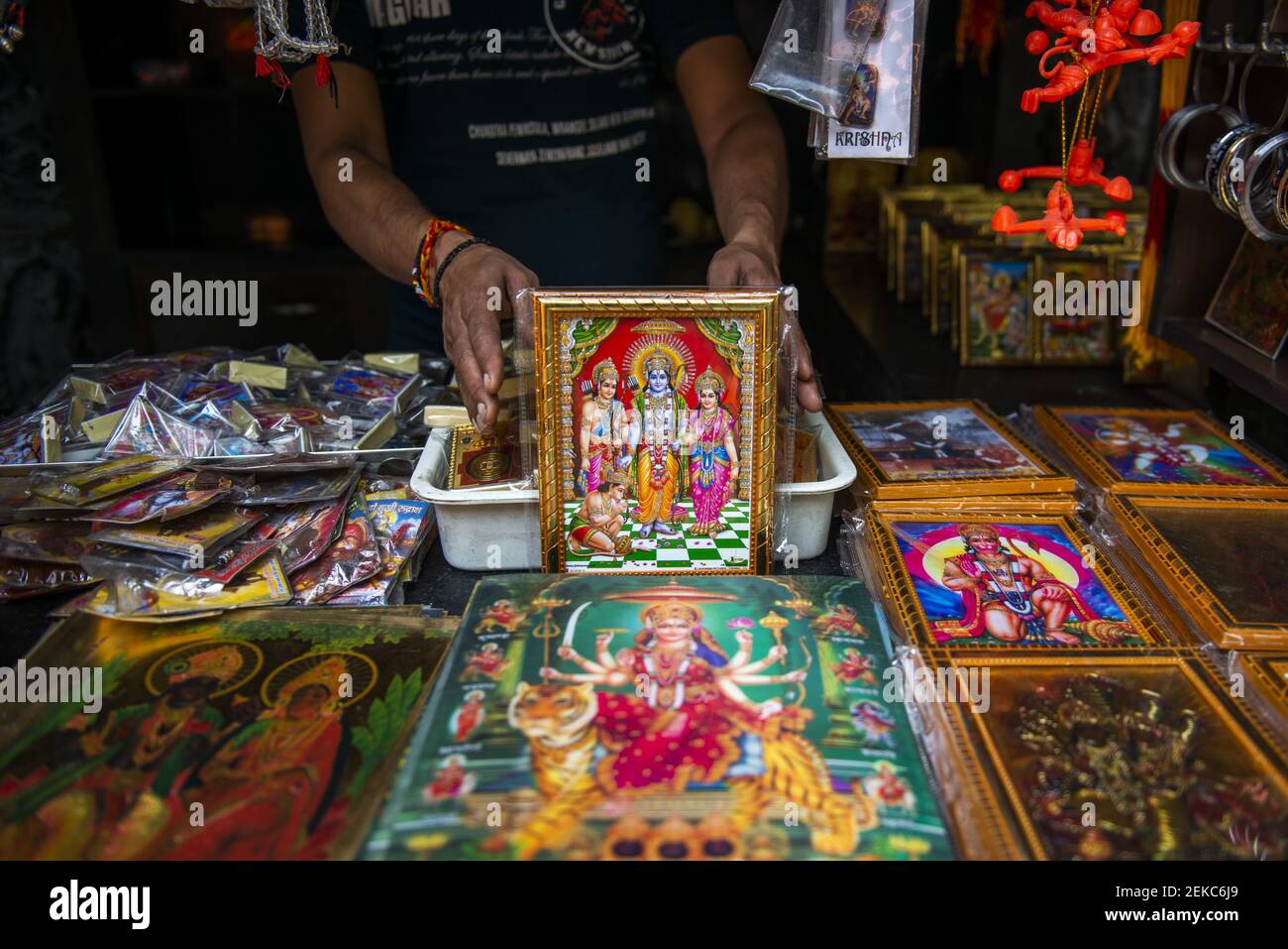 A shopkeeper is seen showing a variety of colourful frames of Lord Rama .  Lord Rama is one of the most adored god and hero of the epic ' Ramayana ' He